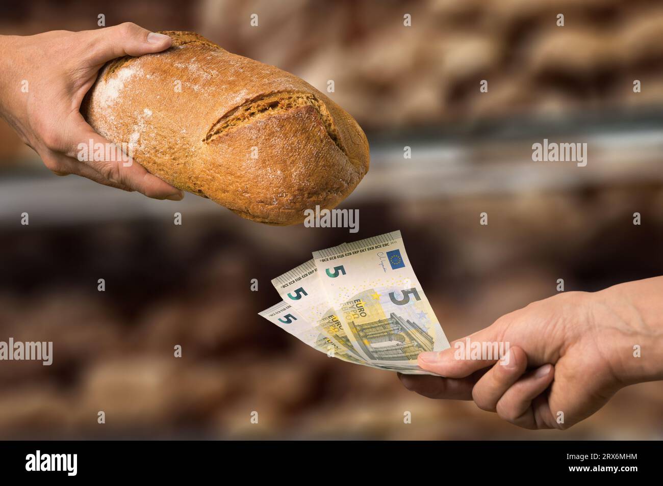 Concetto di inflazione: Pagare 15 euro per una pagnotta di pane. Primo piano tra le mani dell'acquirente e del venditore davanti al banco del pane Foto Stock