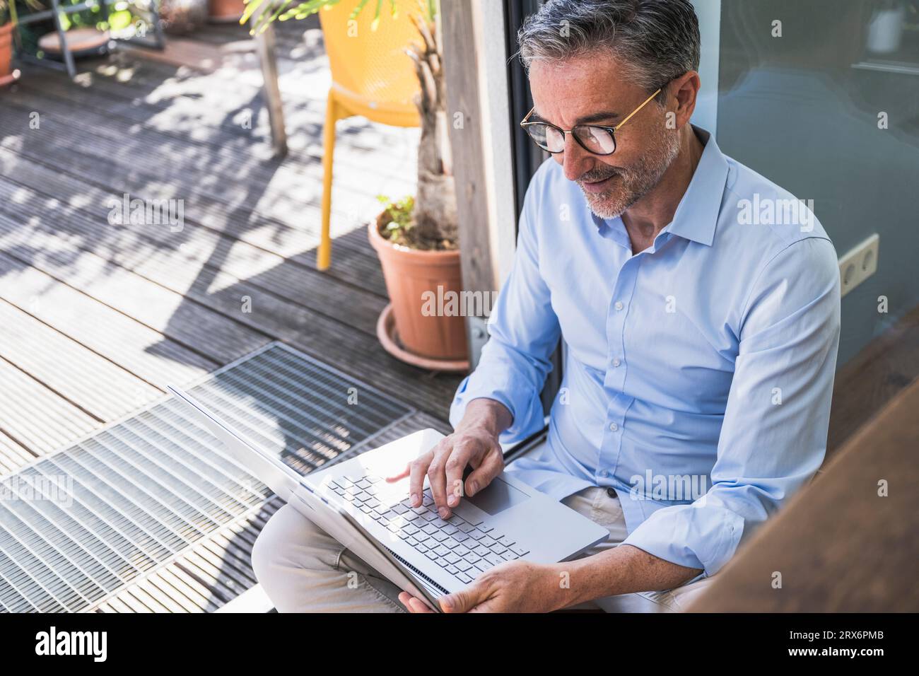 Uomo d'affari maturo che lavora su un notebook in un ufficio domestico Foto Stock