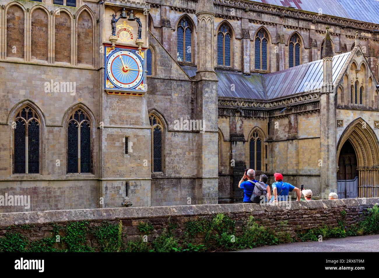 I turisti in attesa del restaurato orologio storico del XIV secolo per suonare all'esterno della Wells Cathedral, Somerset, Inghilterra, Regno Unito Foto Stock
