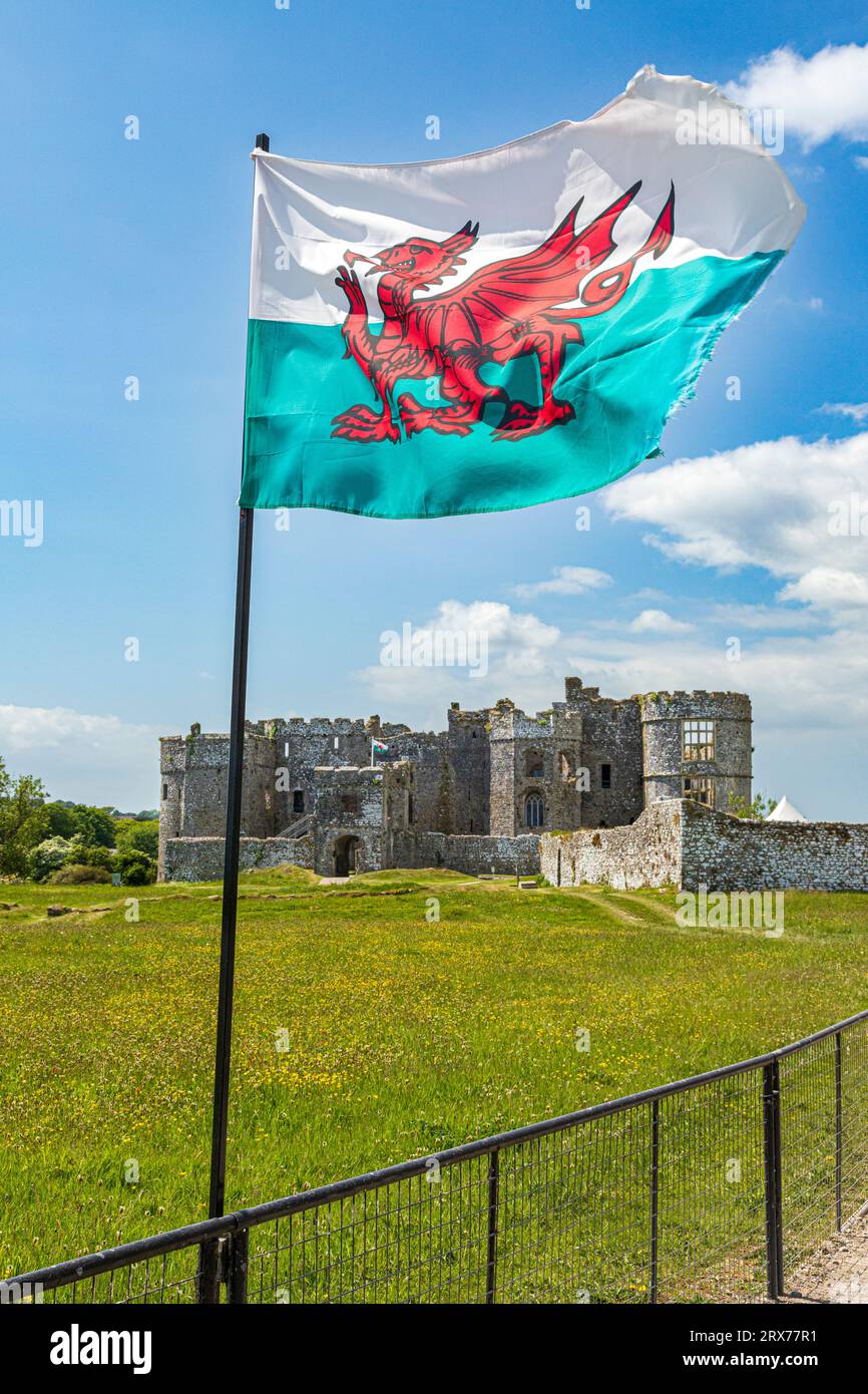 La bandiera gallese sventolante al castello di Carew nel Pembrokeshire Coast National Park, Galles occidentale, Regno Unito Foto Stock