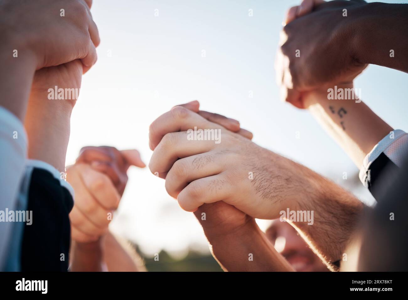 Tenere la mano in alto, solidarietà e sostegno, vincere la competizione e un gruppo di persone all'aperto. Festeggia, missione e partnership con la comunità Foto Stock