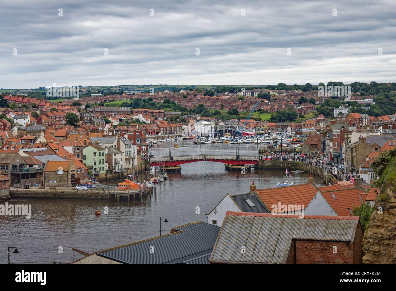 Whitby, Inghilterra, 9, agosto, 2023. Vista da West Cliff, sopra gli edifici con il ponte sospeso e il porto sullo sfondo Foto Stock