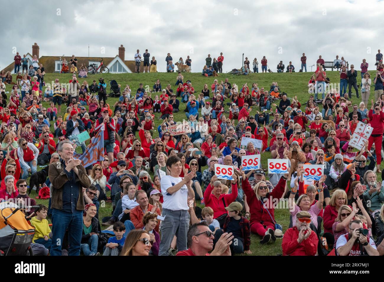 Il comico Paul Whitehouse (a sinistra) e i manifestanti applaudono Feargal Sharkey alla fine del suo discorso alla protesta SOS Whitstable sulle acque reflue nel 2023. Foto Stock