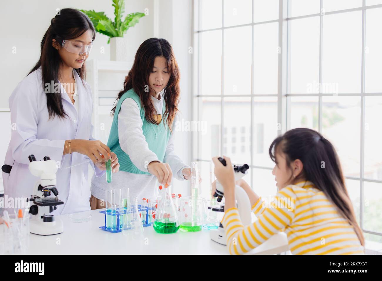 Gruppo di bambini ragazzi adolescenti che giocano in un laboratorio chimico scientifico per l'educazione scolastica Foto Stock