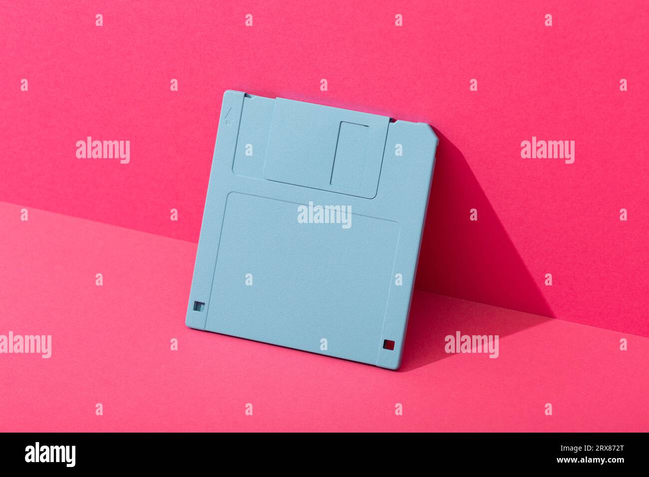 Disco floppy blu su sfondo rosa. Foto di alta qualità Foto Stock