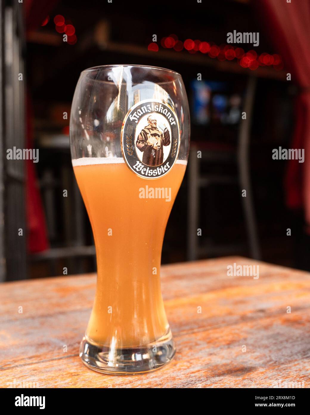 New York City, New York - 21 settembre 2023: Bicchiere di Franziskanker Weissbier al tavolo del bar. Foto Stock