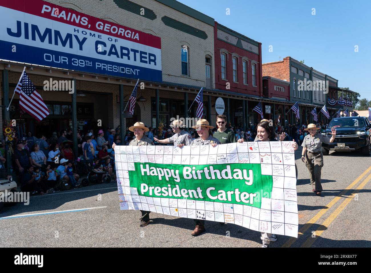 Plains, Stati Uniti. 23 settembre 2023. I National Park Rangers tengono un cartello che celebra il 99° compleanno dell'ex presidente Jimmy Carter mentre marciano al 26° Plains Peanut Festival, il 23 settembre 2023 a Plains, Georgia. L'ex presidente Jimmy Carter e sua moglie Rosalynn Carter furono brevemente avvistati al festival all'interno di un veicolo privato. Crediti: Richard Ellis/Richard Ellis/Alamy Live News Foto Stock