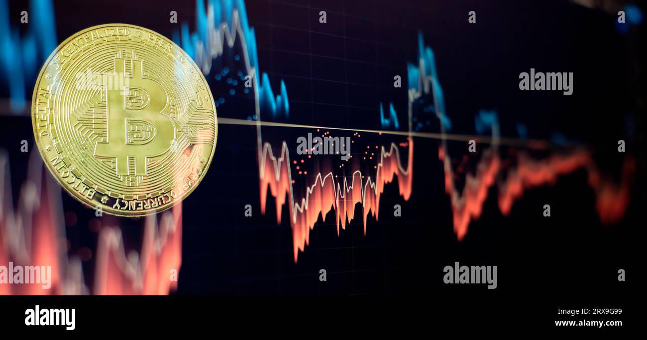 Bitcoin criptovaluta Gold Coin e grafico sfocato Foto Stock
