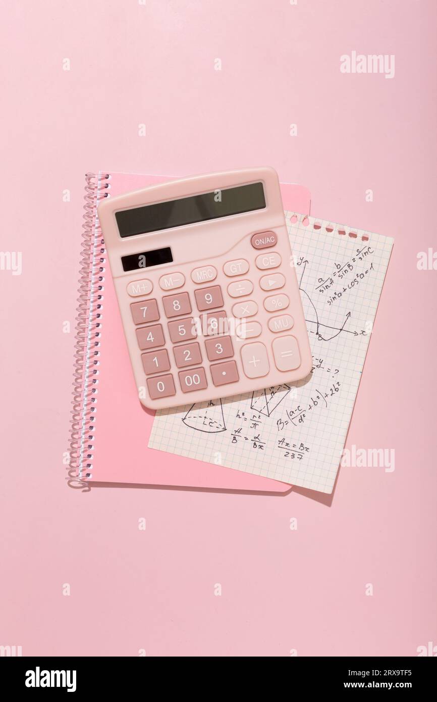 Su sfondo rosa, materiale scolastico rosa, calcolatrice, cheat sheets. Foto di alta qualità Foto Stock