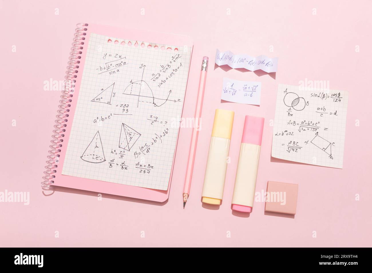 Su sfondo rosa, materiale scolastico rosa, calcolatrice, cheat sheets. Foto di alta qualità Foto Stock