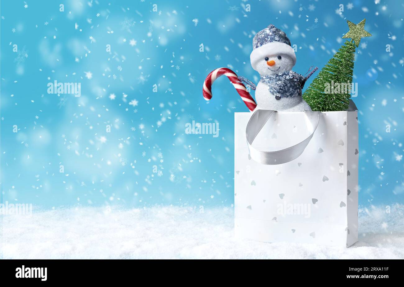 Pupazzo di neve di Natale con borsa della spesa sulla neve e regalo di Natale. Banner sconti invernali. Regali di consegna. Regalo Snowman Foto Stock