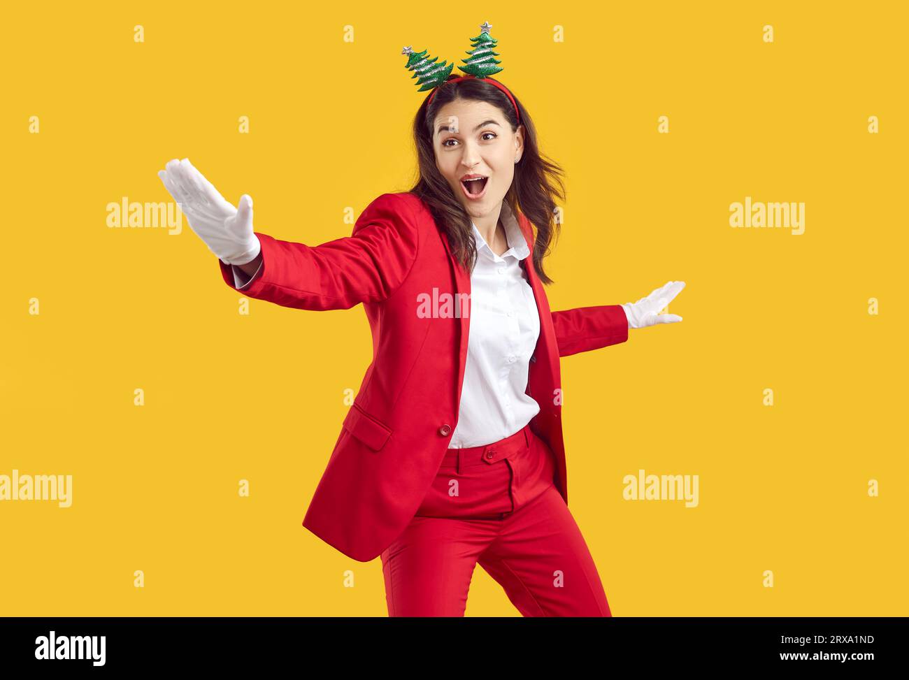 Pazza ballerina di Natale emotivo che indossa balli in stile Babbo Natale su sfondo giallo. Foto Stock