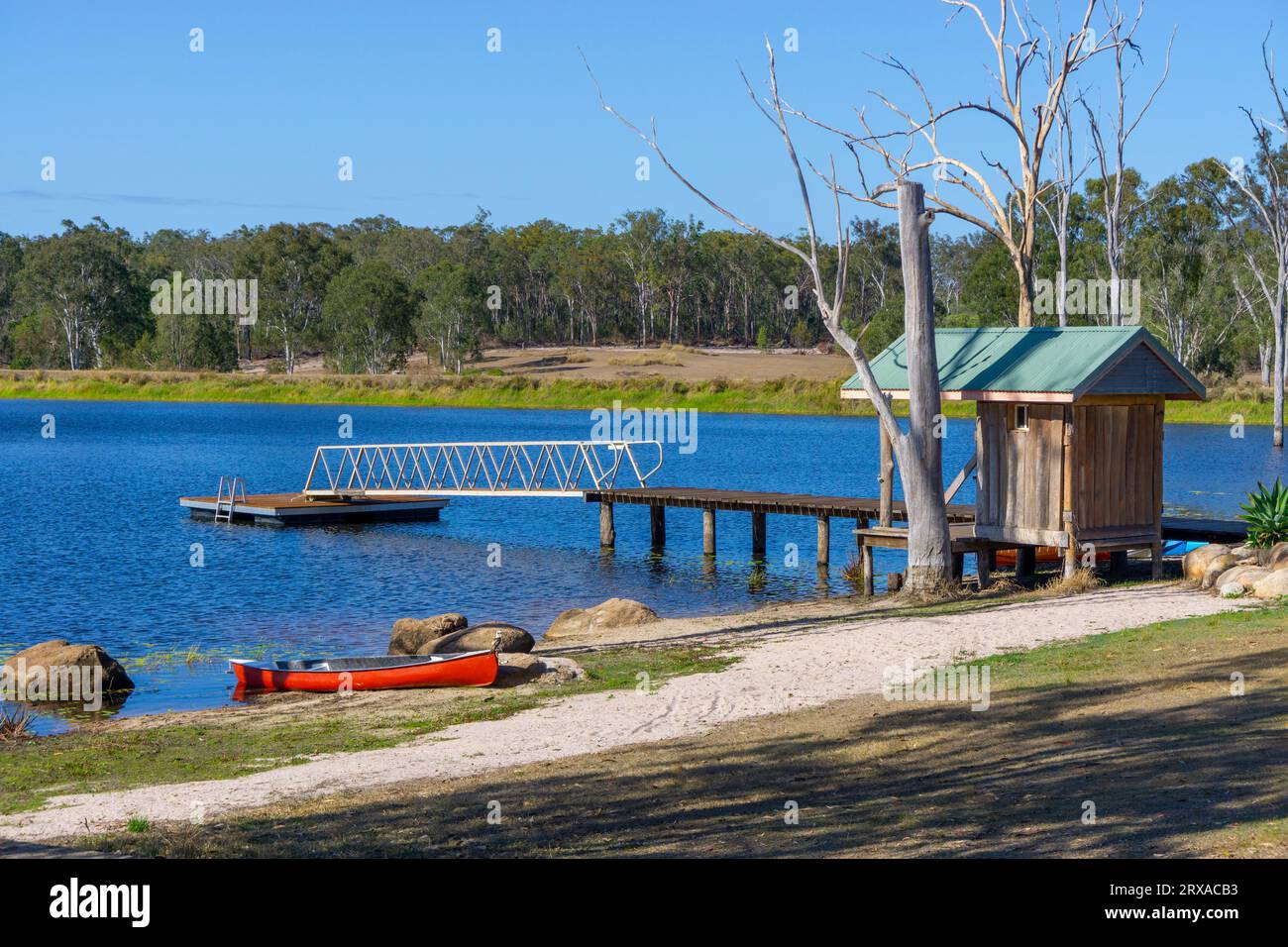 Kayak sulla spiaggia sabbiosa della diga d'acqua dolce in molo con pontone nelle giornate di sole presso il campeggio rurale. Childers Queensland, Australia Foto Stock
