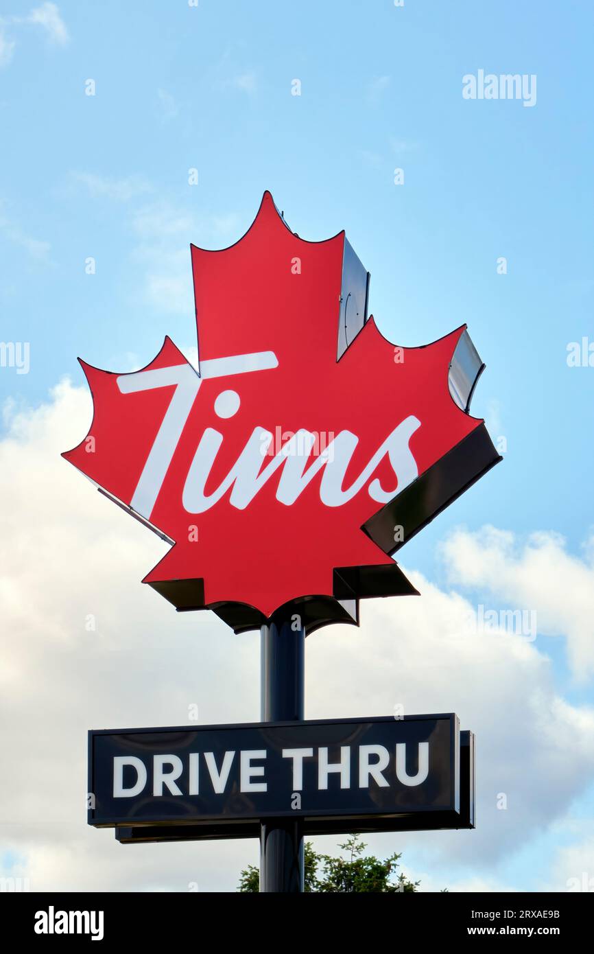 Il cartello di Tim Hortons con il nuovo logo aggiornato fotografato con orientamento verticale in un cielo bellissimo. Foto Stock