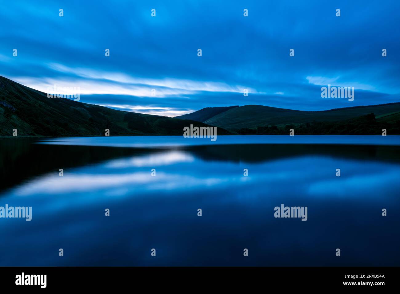 La luce dell'ora blu catturata all'alba a Glenbuck Loch vicino a Muirkirk nell'East Ayrshire, in Scozia. Foto Stock