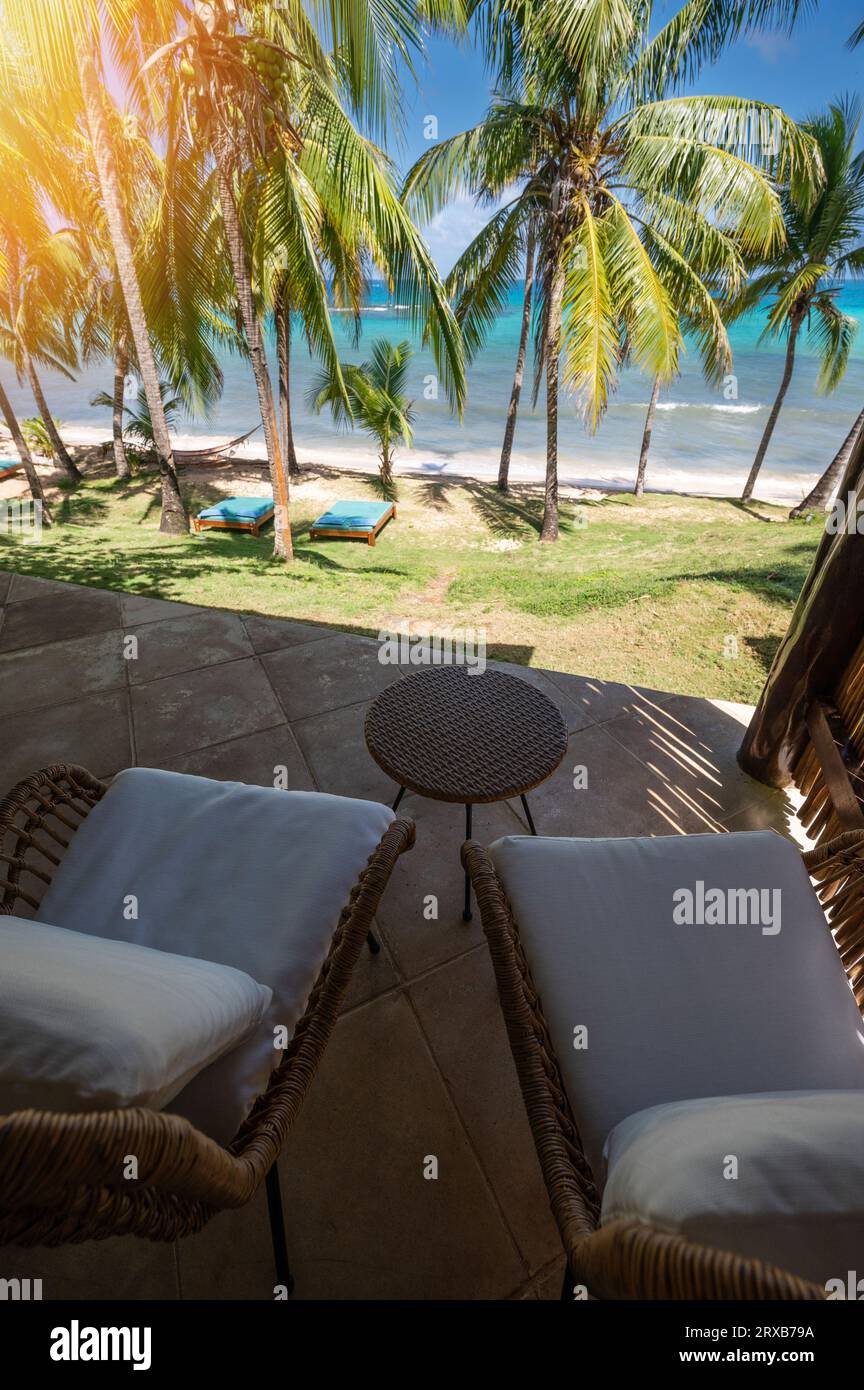 Sedia e tavolino da caffè sulla terrazza con sfondo tropicale caraibico Foto Stock