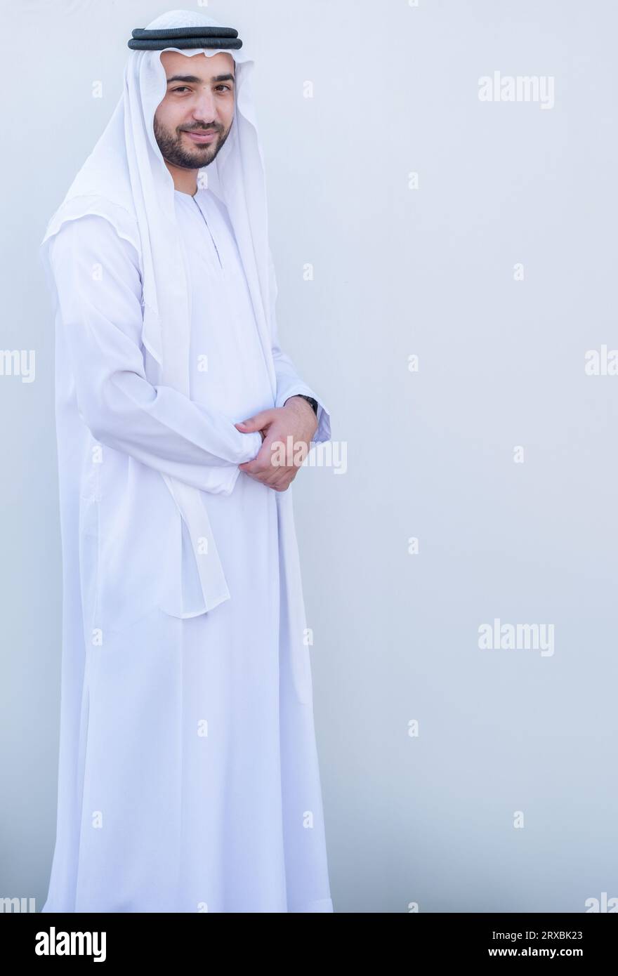 Lato giovanile arabo in piedi in modo sicuro su sfondo bianco isolato Foto Stock