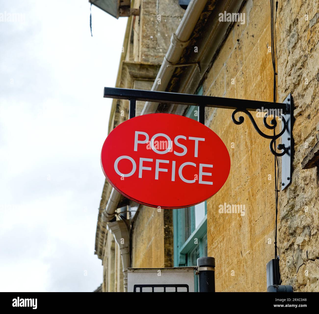 Primo piano di un cartello appeso per l'ufficio postale a Burford, Oxfordshire, Cotswolds, Inghilterra, Regno Unito Foto Stock