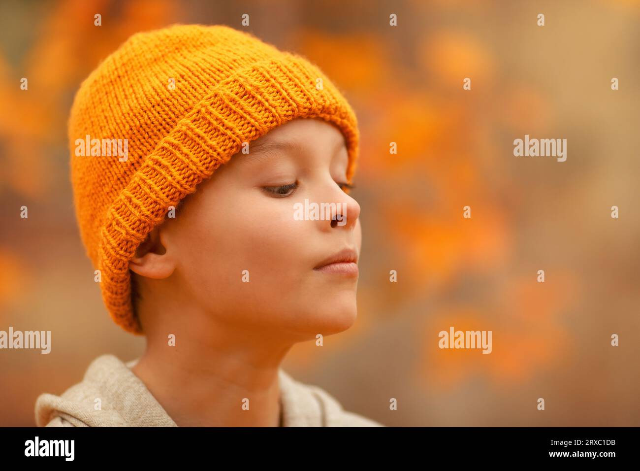 Ragazzo in cappello sorride nel parco autunnale. Foto Stock