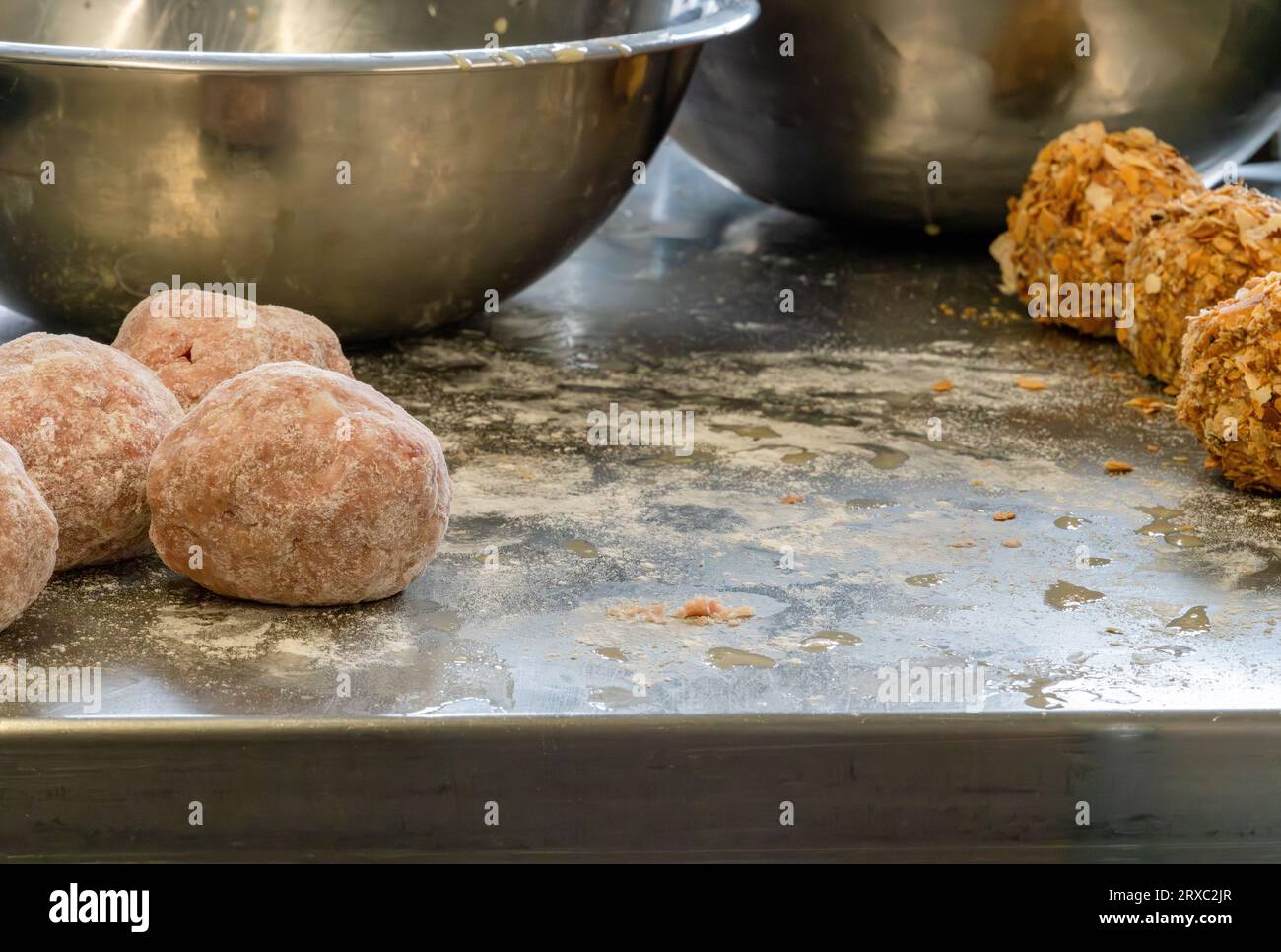 Il processo di creazione delle uova di scotch prevede l'utilizzo di farina e lavaggio delle uova, che possono lasciare residui disordinati sul tavolo di metallo. Foto Stock