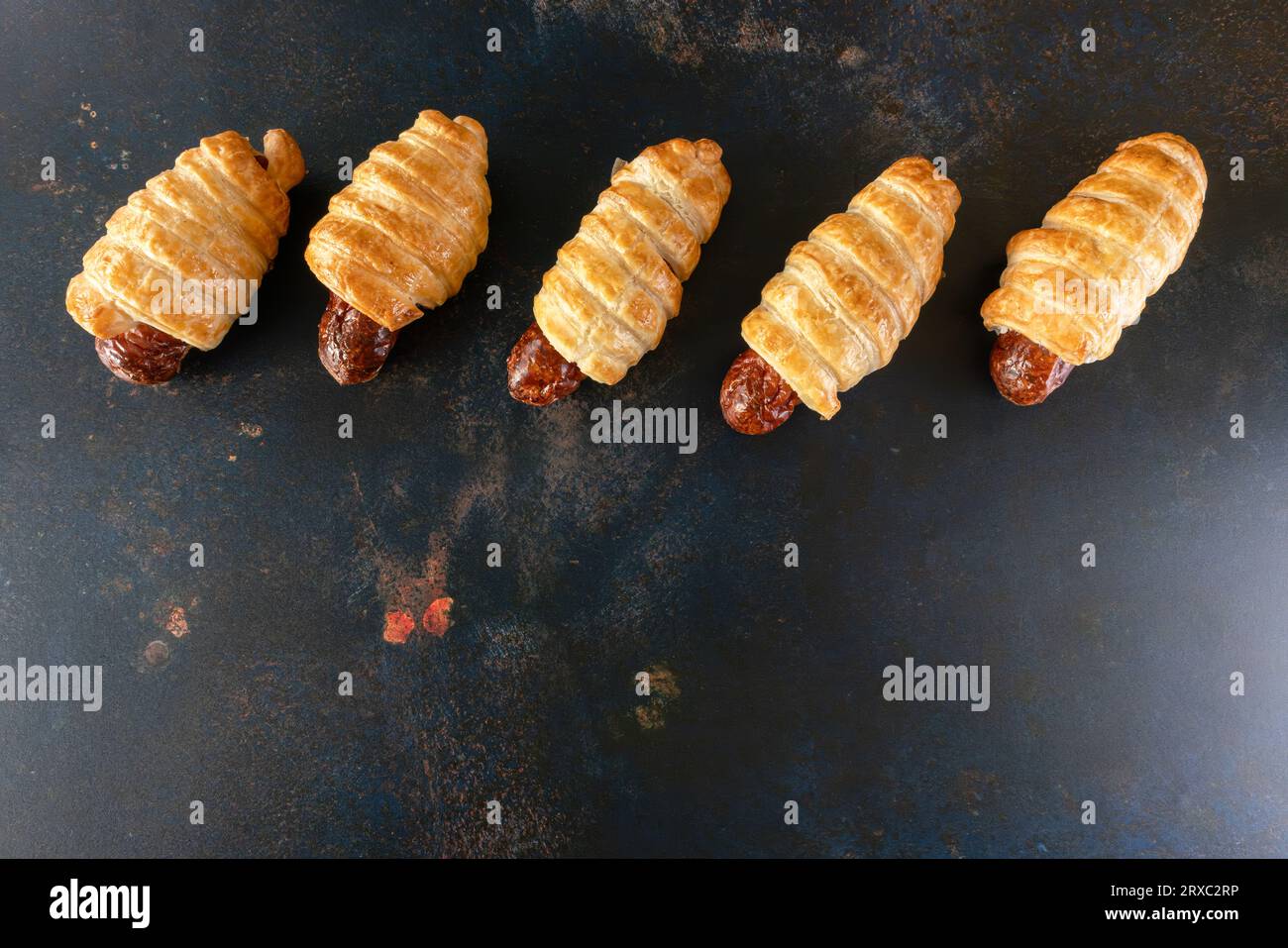 I mini panini di salsiccia sono presentati come uno spuntino in uno sfondo rustico. Foto Stock