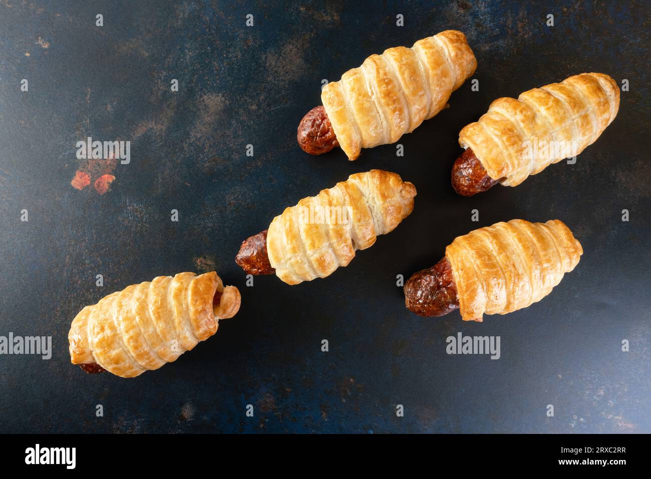 I mini panini di salsiccia sono presentati come uno spuntino in uno sfondo rustico. Foto Stock