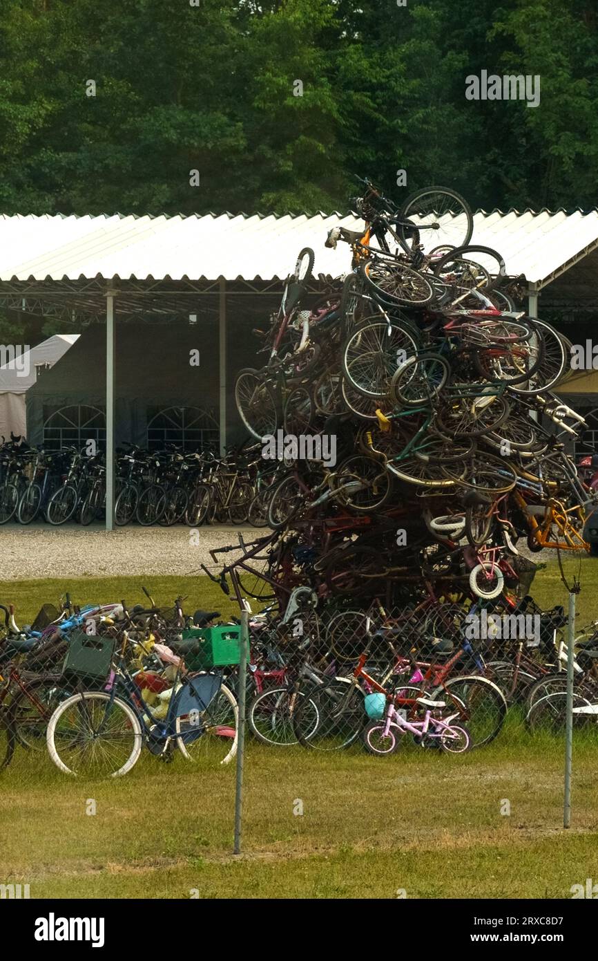 Una montagna di vecchie biciclette si trova in un'area verde. Foto Stock