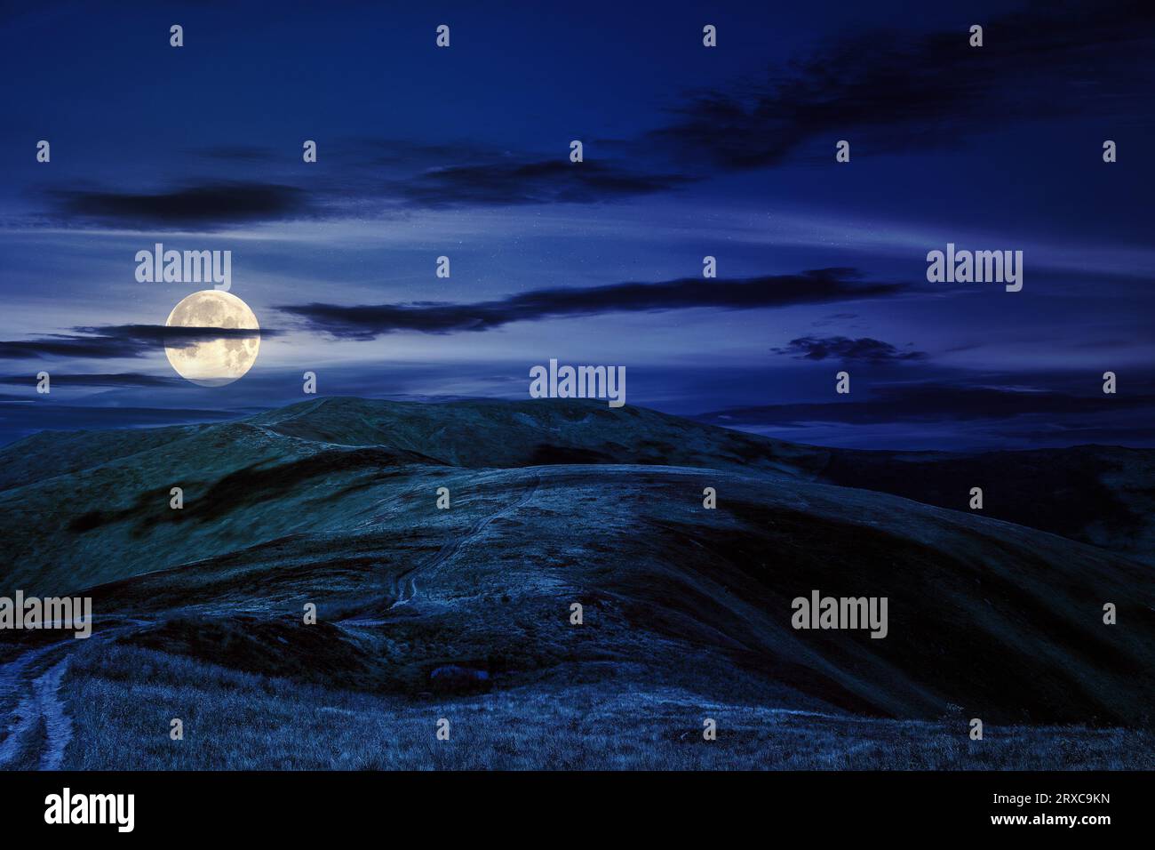 paesaggio montano di notte. percorso tra le colline fino alla cima della montagna. splendido paesaggio naturale con la luce della luna piena Foto Stock