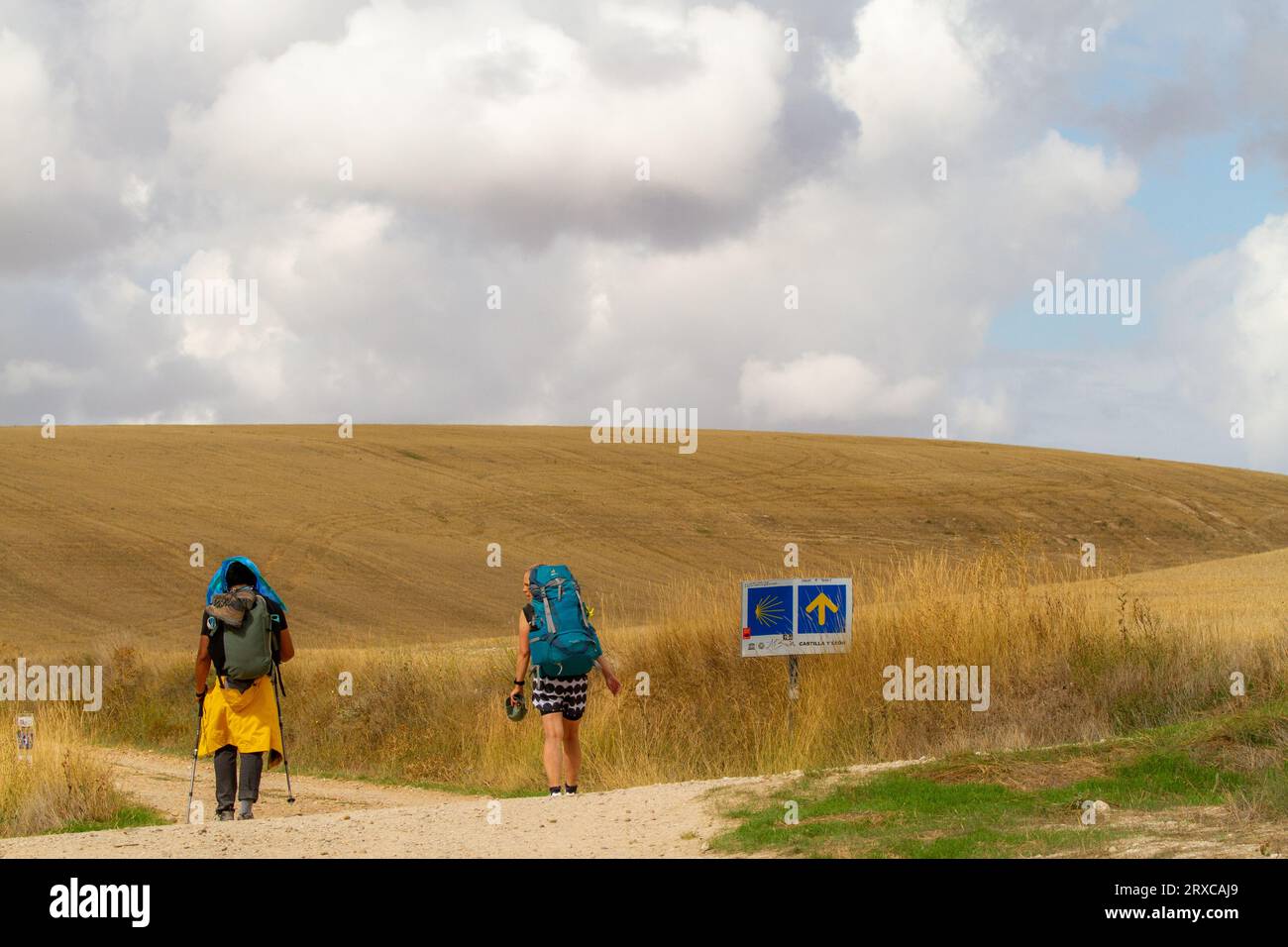 Pellegrini che camminano lungo il cammino di Santiago, il cammino di San Giacomo, attraverso la campagna spagnola tra Hornillos e Hontanas Spagna Foto Stock