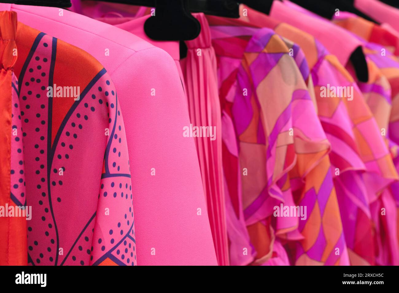 Abiti rossi per la famiglia sugli appendiabiti in negozio Foto Stock
