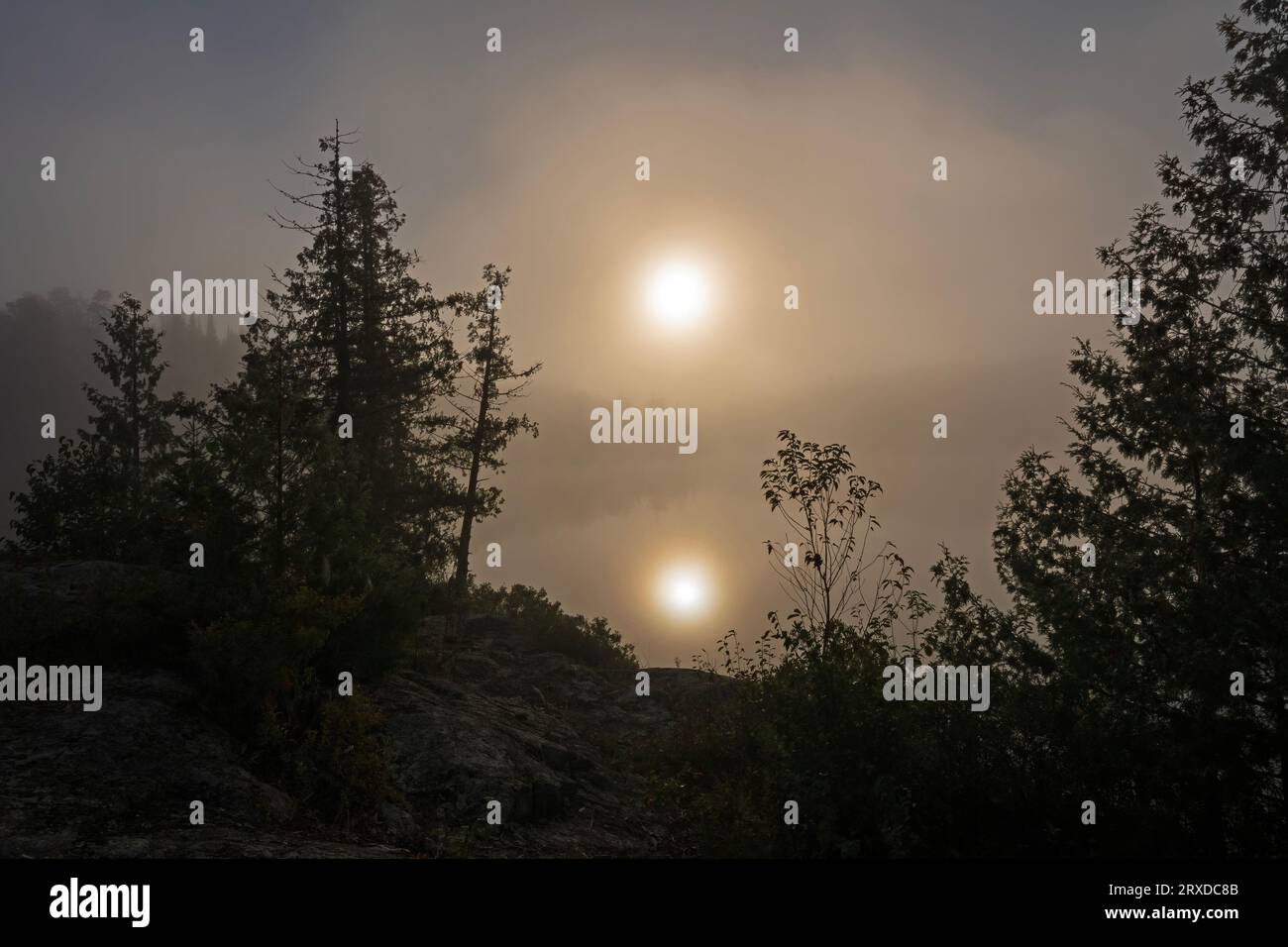Riflessioni del sole e sagome al mattino sul lago Jenny nelle acque del confine in canoa sono in Minnesota Foto Stock