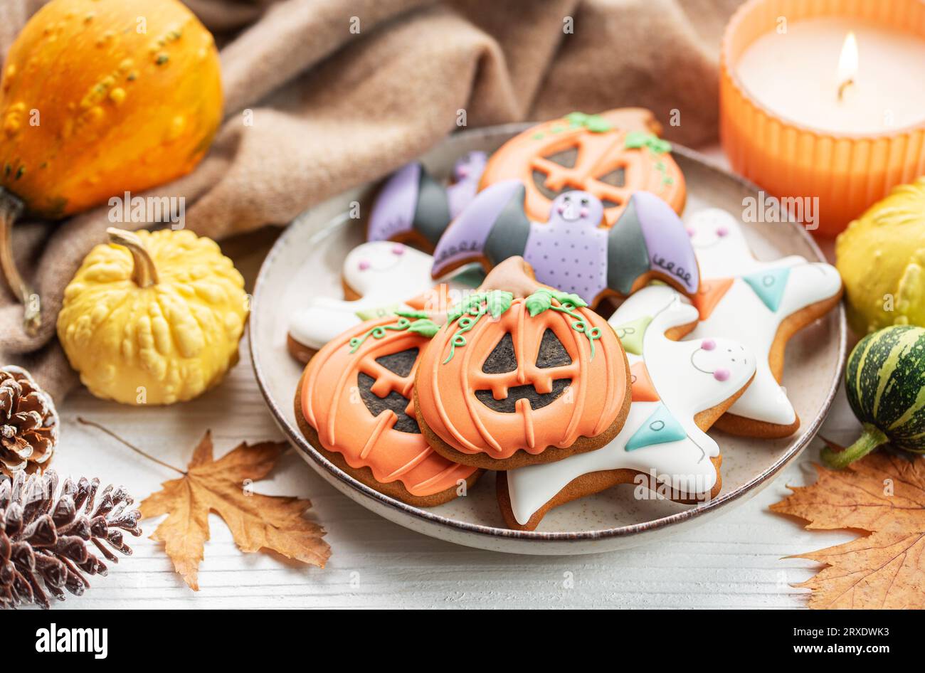 Biscotti fatti in casa multicolori di Halloween su sfondo di legno bianco. Foto Stock