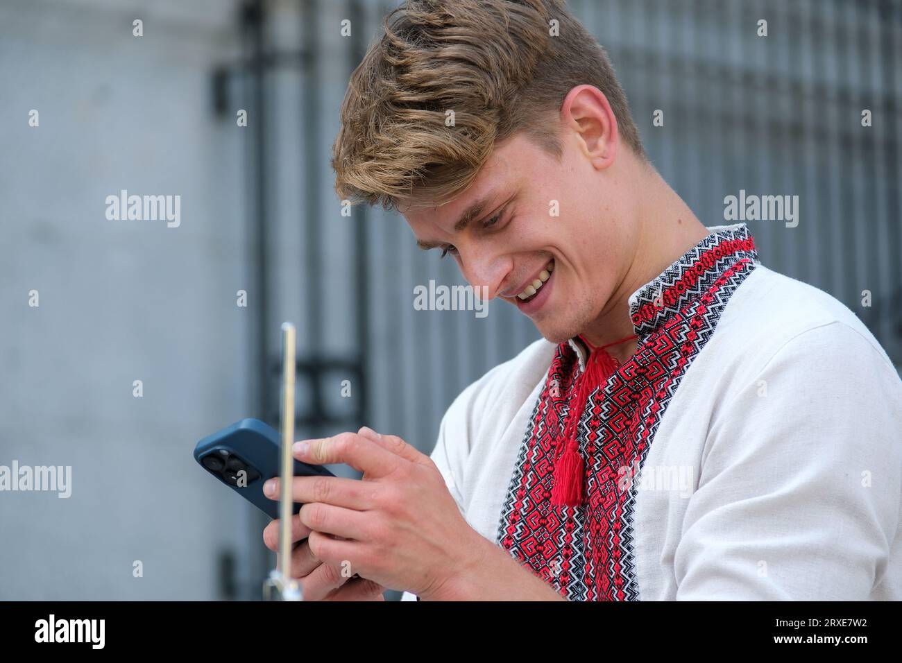 Giocate magistralmente il bellissimo ragazzo di aspetto europeo con la camicia ricamata Ucraina abiti nazionali dell'Ucraina suonano i bastoncini del tamburo. potere della felicità professionalità Foto Stock