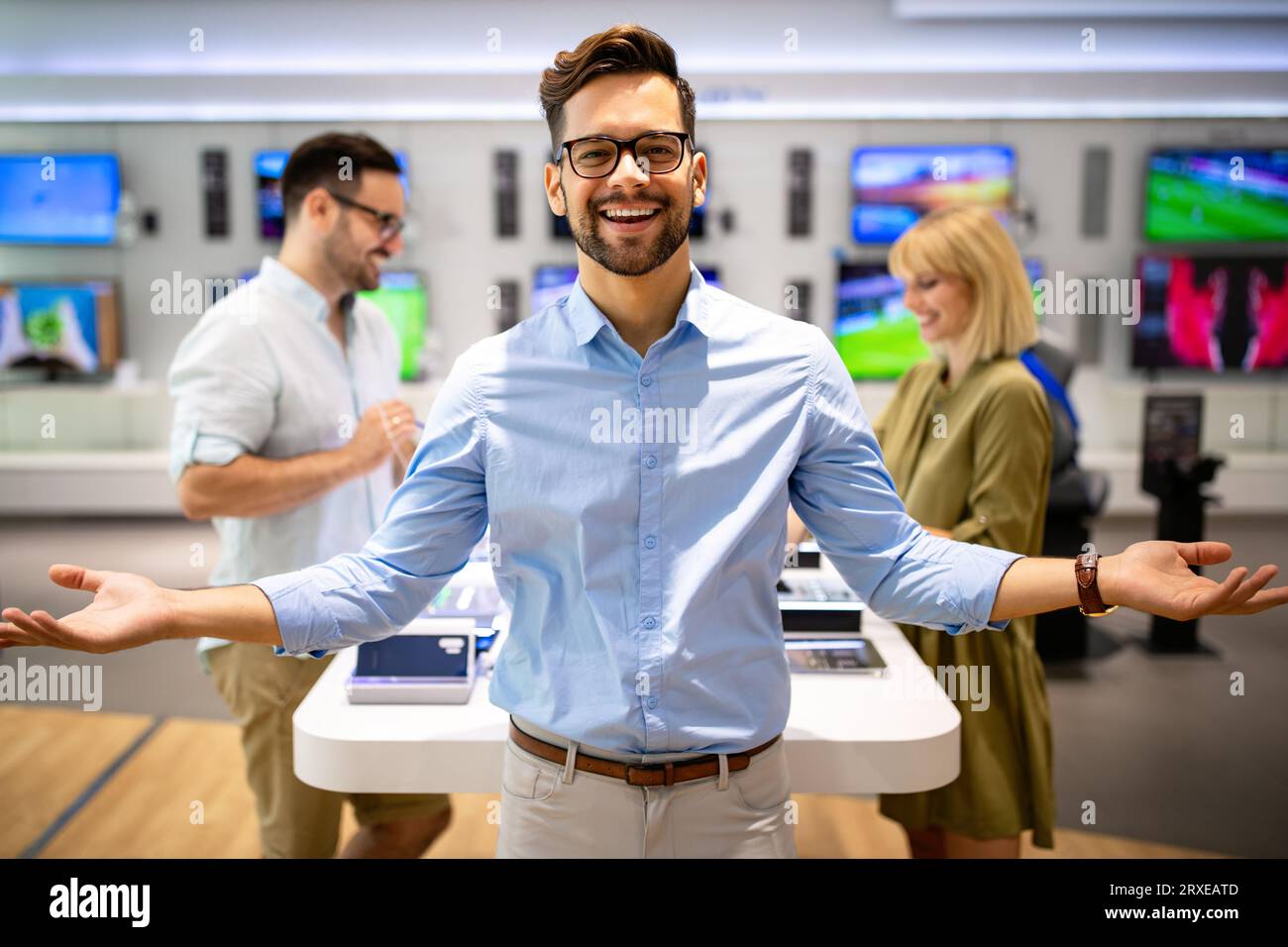 Il consulente di vendita consiglia le persone che scelgono nuovi dispositivi digitali nei punti vendita. Consulenza professionale Foto Stock