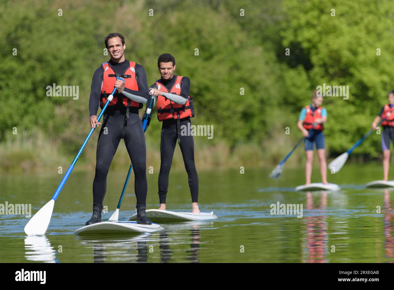 i giovani erano in piedi sulle tavole da paddle Foto Stock