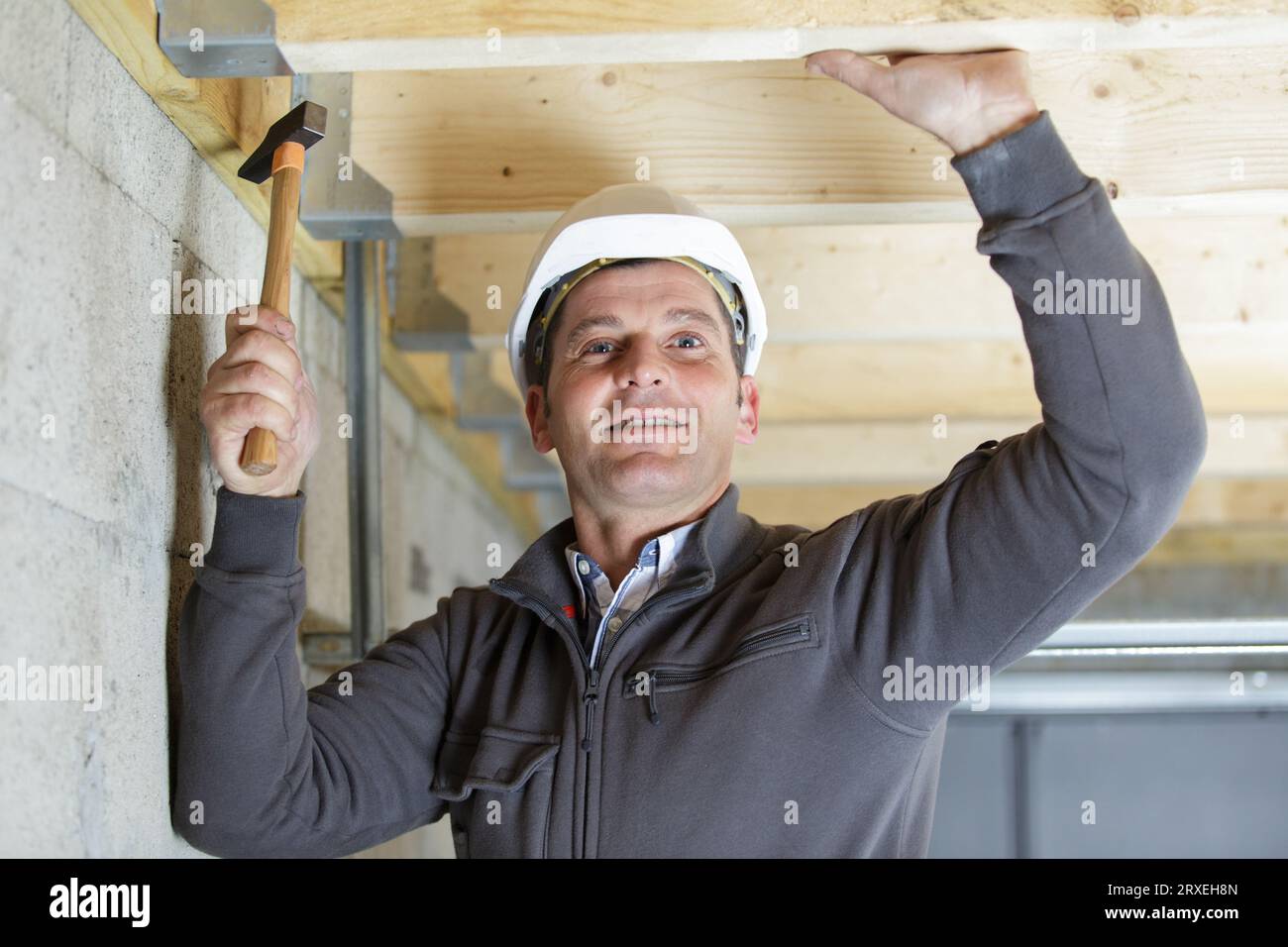 martello per muratore maturo e felice struttura in legno per interni Foto Stock