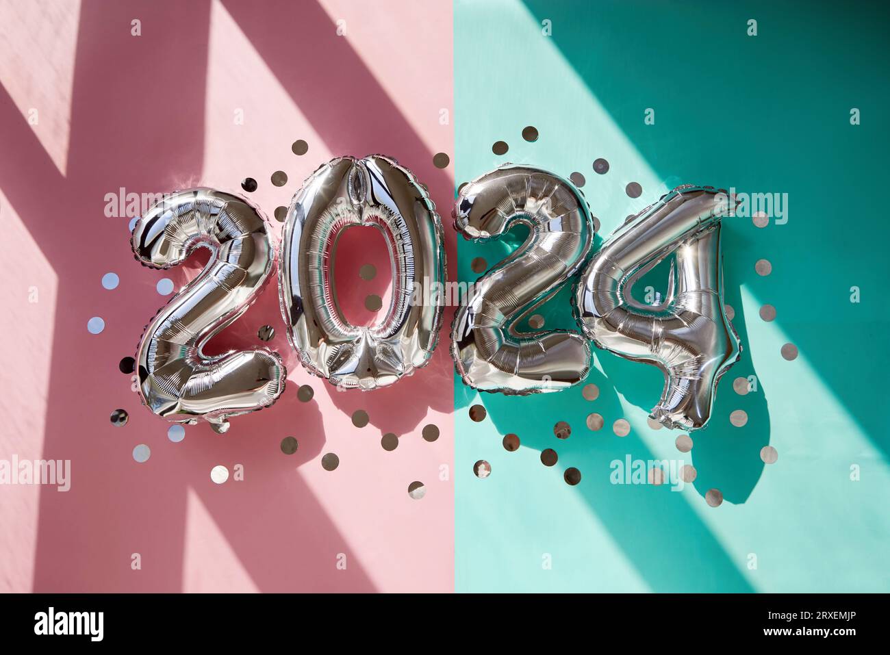 Silver conta 2024 palloncini per il nuovo anno su sfondo turchese rosa al sole Foto Stock
