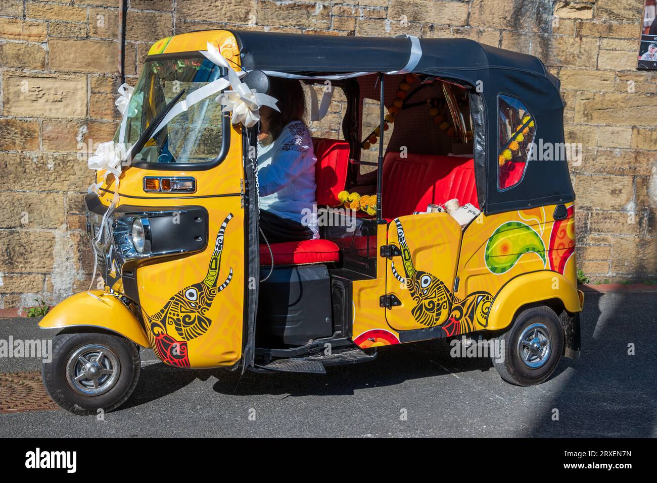 Risciò TucTuc arancione brillante vestito da auto nuziale. Foto Stock