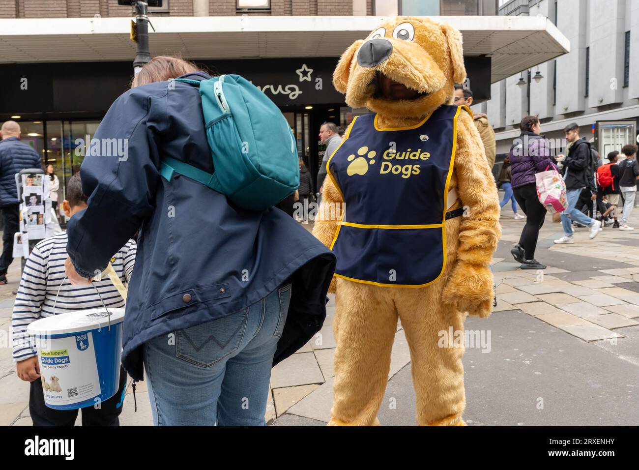 Una persona in costume da cane raccoglie denaro per l'associazione benefica Guide Dogs. Foto Stock