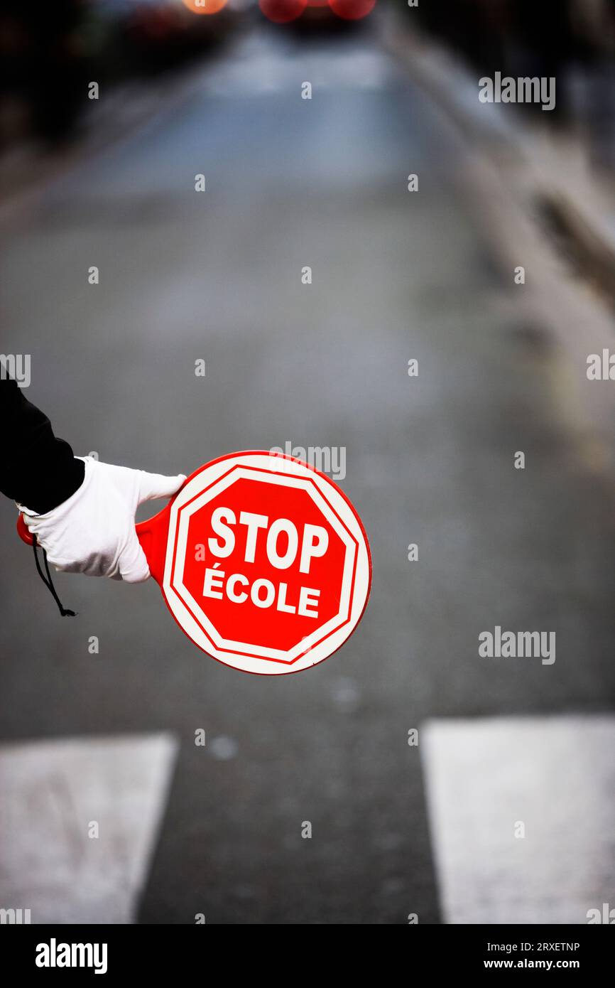 Una mano con un cartello di stop in francese e inglese. Foto Stock