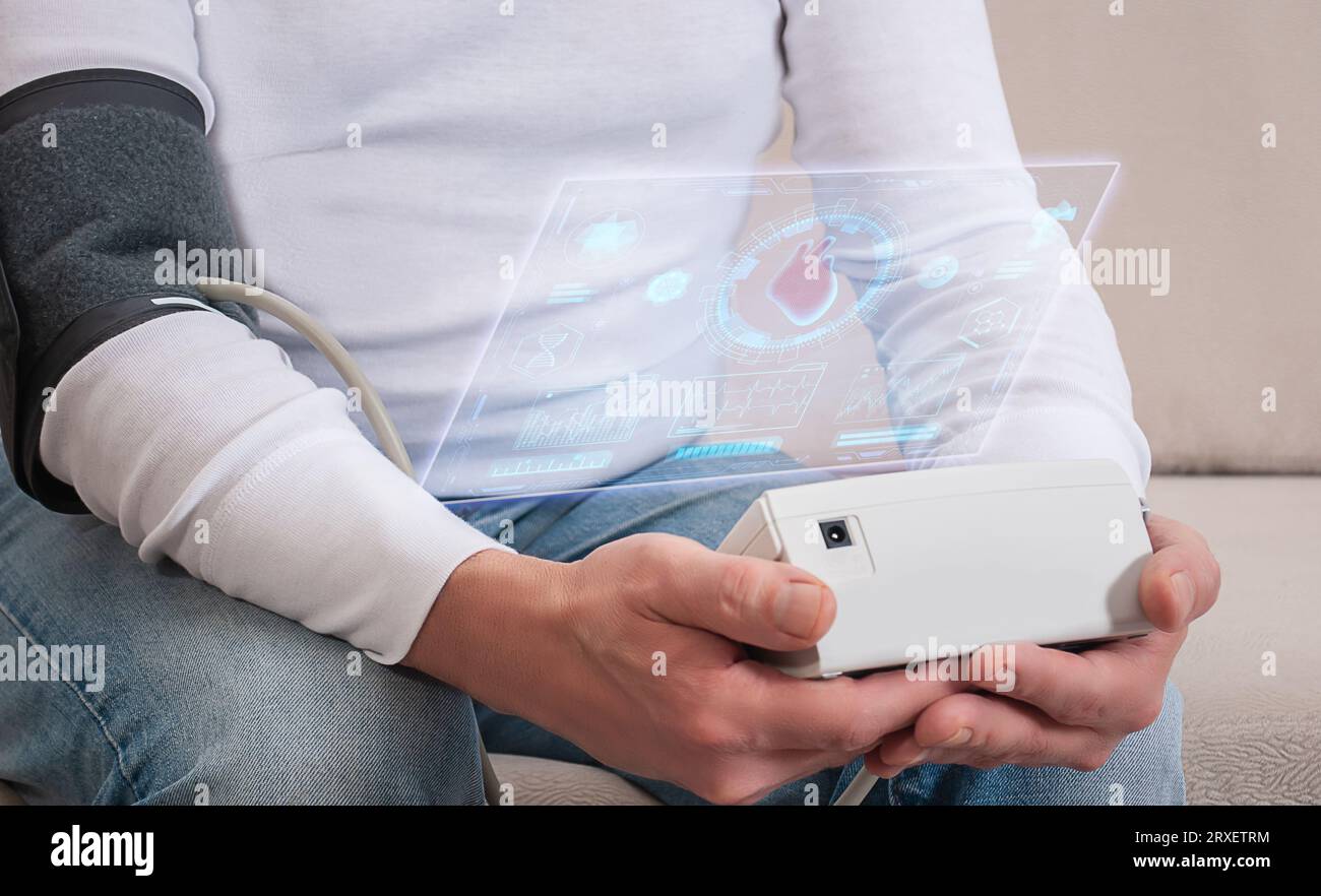 Un uomo prende la pressione sanguigna con un dispositivo automatico da vicino Foto Stock