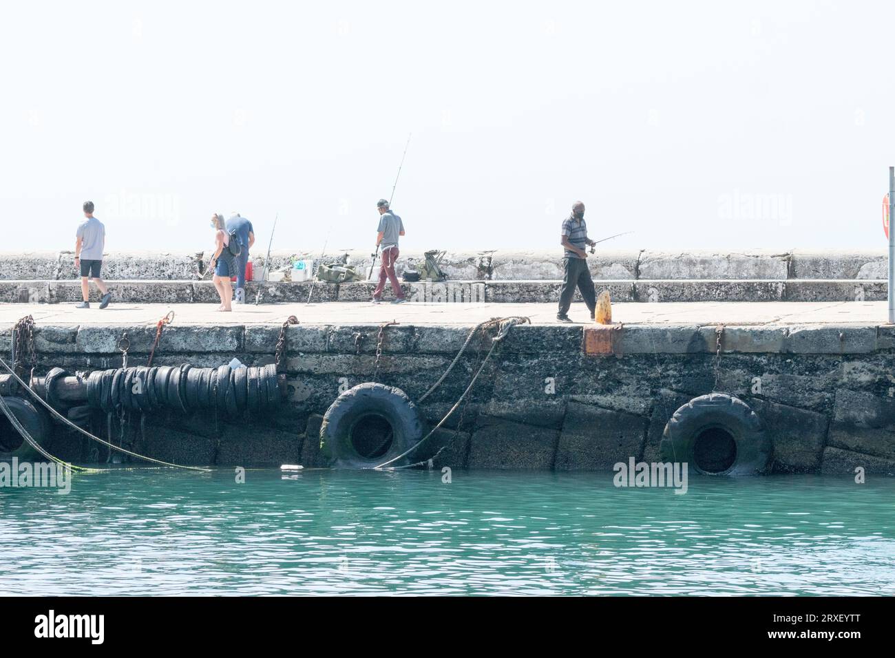 Scena di alto livello su una parete del porto di pescatori e persone che amano attività ricreative o ricreative a Kalk Bay, Western Cape, Sud Africa Foto Stock