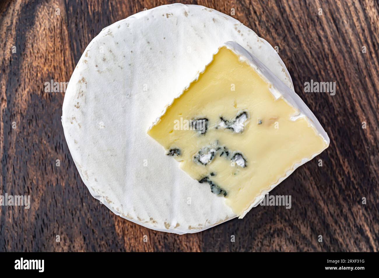 Un pezzo di formaggio blu, formaggio con muffa su trama di legno. Cucina tradizionale francese Foto Stock