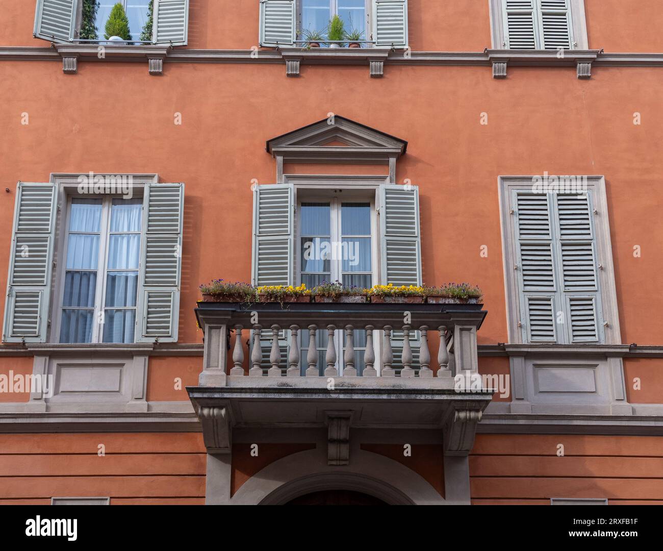 Facciata di un antico palazzo in stile neoclassico con balcone decorato con piante in vaso, Parma, Emilia-Romagna, Italia Foto Stock