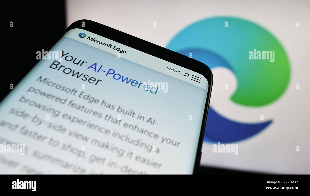 Smartphone con sito Web del browser Web Microsoft Edge sullo schermo davanti al logo aziendale. Mettere a fuoco in alto a sinistra sul display del telefono. Foto Stock