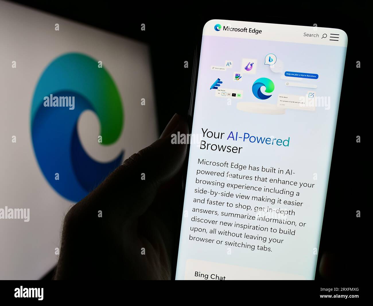 Persona che possiede il cellulare con una pagina Web del browser Web Microsoft Edge sullo schermo davanti al logo del prodotto. Concentrarsi sul centro del display del telefono. Foto Stock