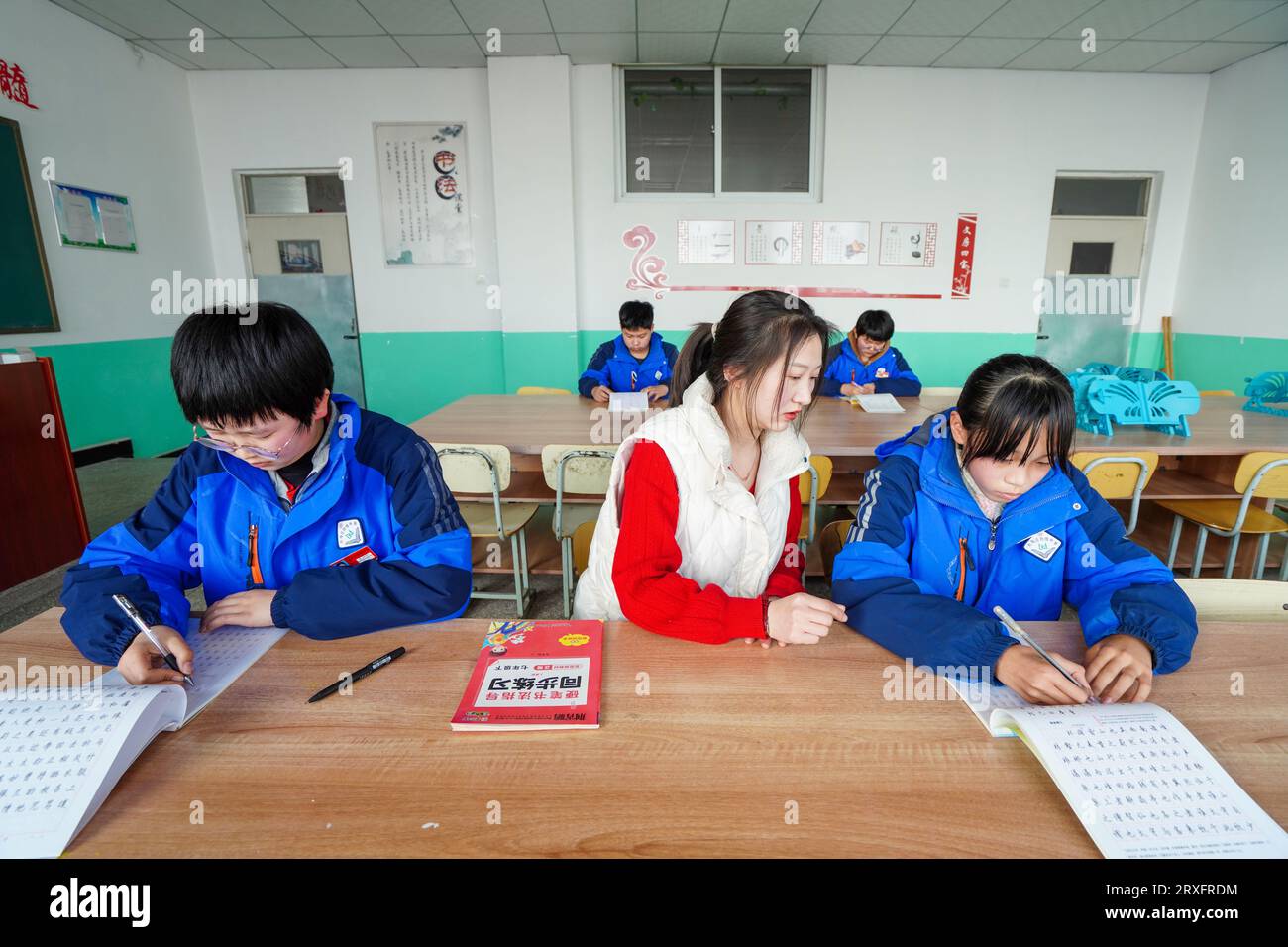 Luannan, Cina - 9 marzo 2023: Insegnante femminile guida gli studenti nella pratica della calligrafia, Cina settentrionale Foto Stock