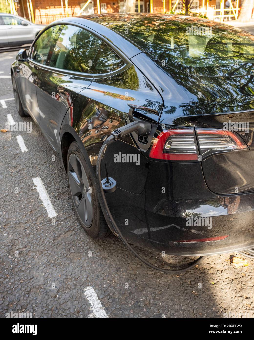 Londra, Regno Unito. 25 settembre 2023. Un'auto elettrica Tesla in carica a Pimlico. L'Associazione europea dei costruttori di automobili (ACEA) ha affermato che le nuove norme commerciali Brexit impongono che i veicoli elettrici siano dotati di batterie prodotte nel Regno Unito o nell'UE. Le auto che non soddisfano i criteri devono far fronte a tariffe del 10% con un costo per i produttori europei di 3,75 miliardi di sterline nei prossimi 3 anni. I produttori affermano di non essere pronti con le fabbriche di produzione di batterie e il costo delle tariffe aumenterà i prezzi al consumo. Crediti: Stephen Chung / Alamy Live News Foto Stock