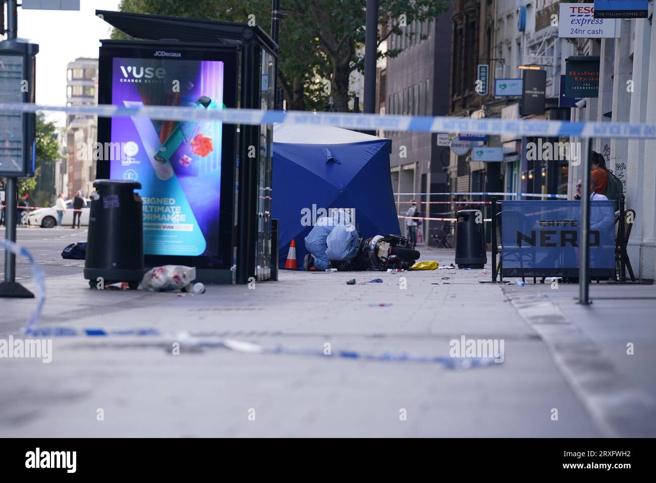 Agenti forensi della polizia sulla scena di una collisione mortale su Tottenham Court Road, nel centro di Londra. Un motociclista di 18 anni seguito dalla polizia è morto dopo un incidente con un taxi e un arredamento stradale intorno alle 6:45 di lunedì. Il passeggero della pillione, che è stato trovato avere un machete, è stato portato in ospedale per lesioni alle gambe e alle braccia e arrestato. Foto Stock