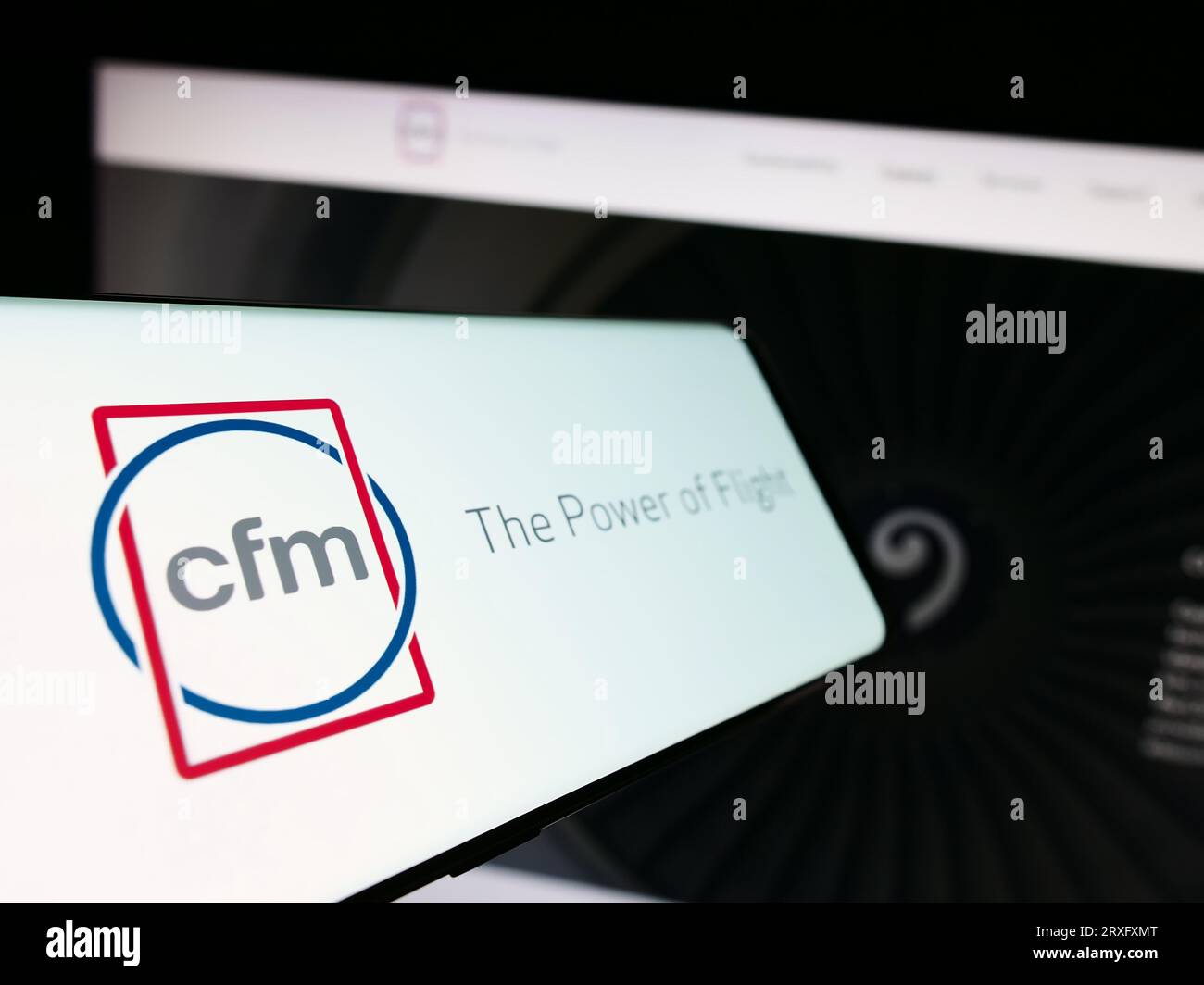 Smartphone con logo della società di motori aeronautici CFM International sullo schermo di fronte al sito Web aziendale. Mettere a fuoco il display centrale sinistro del telefono. Foto Stock